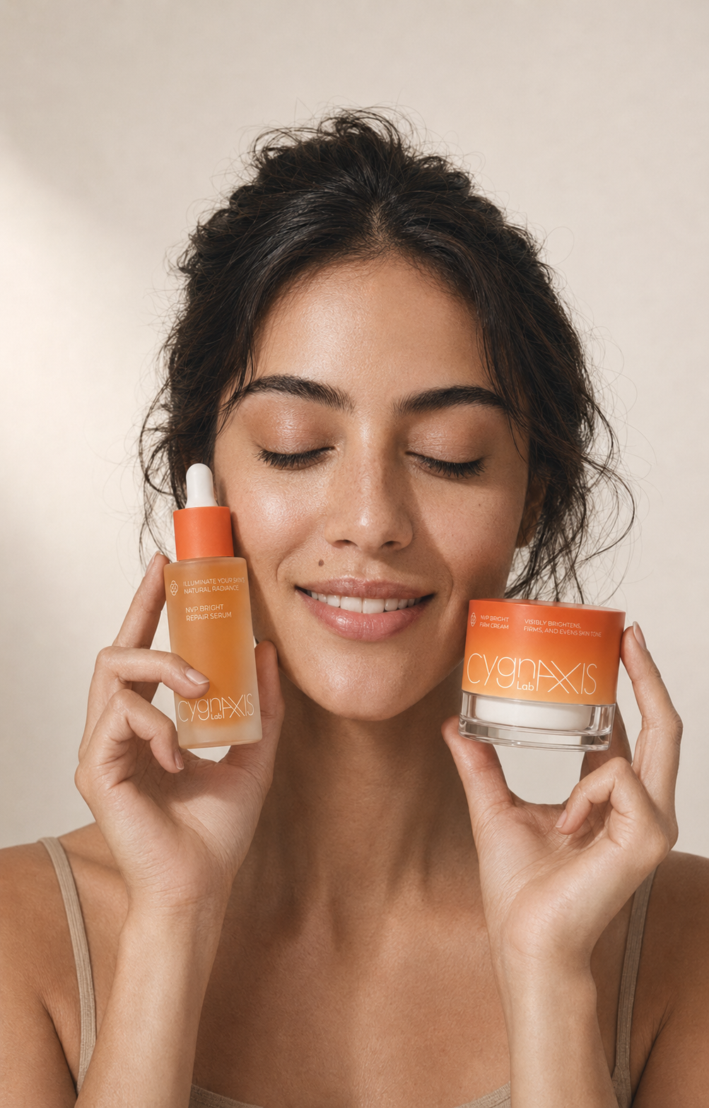 Woman holding NVP Bright Repair Serum and NVP Bright Firm Cream beside her face.