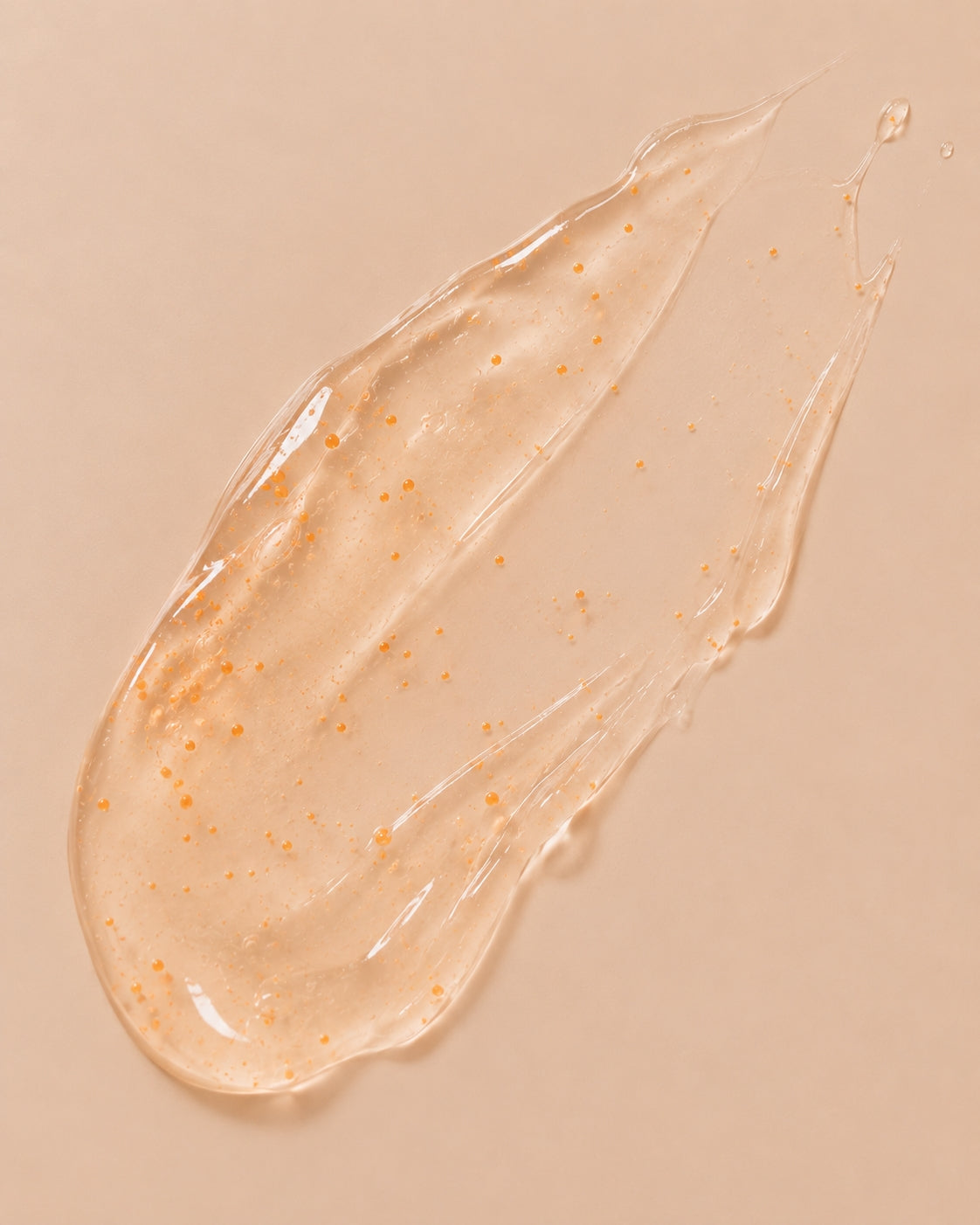Close-up of translucent serum texture with visible orange microbeads.